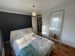 Another view into the room, this time looking towards the door. The grey feature wall is visible behind the bed, because I haven't started painting it yet. There's a little bit of masking around the door frame and some plastic sheets covering a large mirror on the wall.